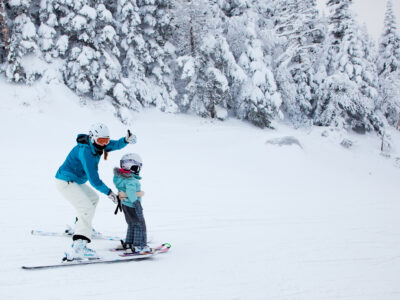 Mont Tremblant - February 9, 2014: A mother is teaching her young daugther to ski down an easy slope at Mont-Tremblant Ski Resort. Mont-Tremblant Ski Resort is acknowledged, by most industry experts, as being the best ski resort in Eastern North America.